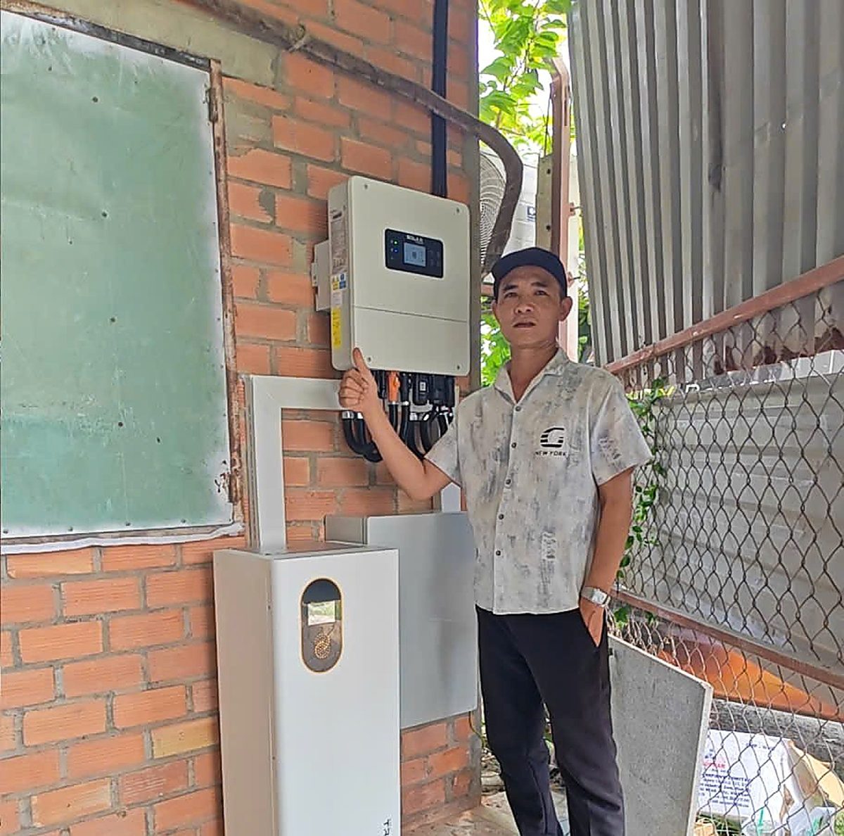 Chủ nhà đứng cạnh biến tần hybrid và pin lưu trữ mới lắp, Minh Thắng Solar bàn giao tại Tây Ninh