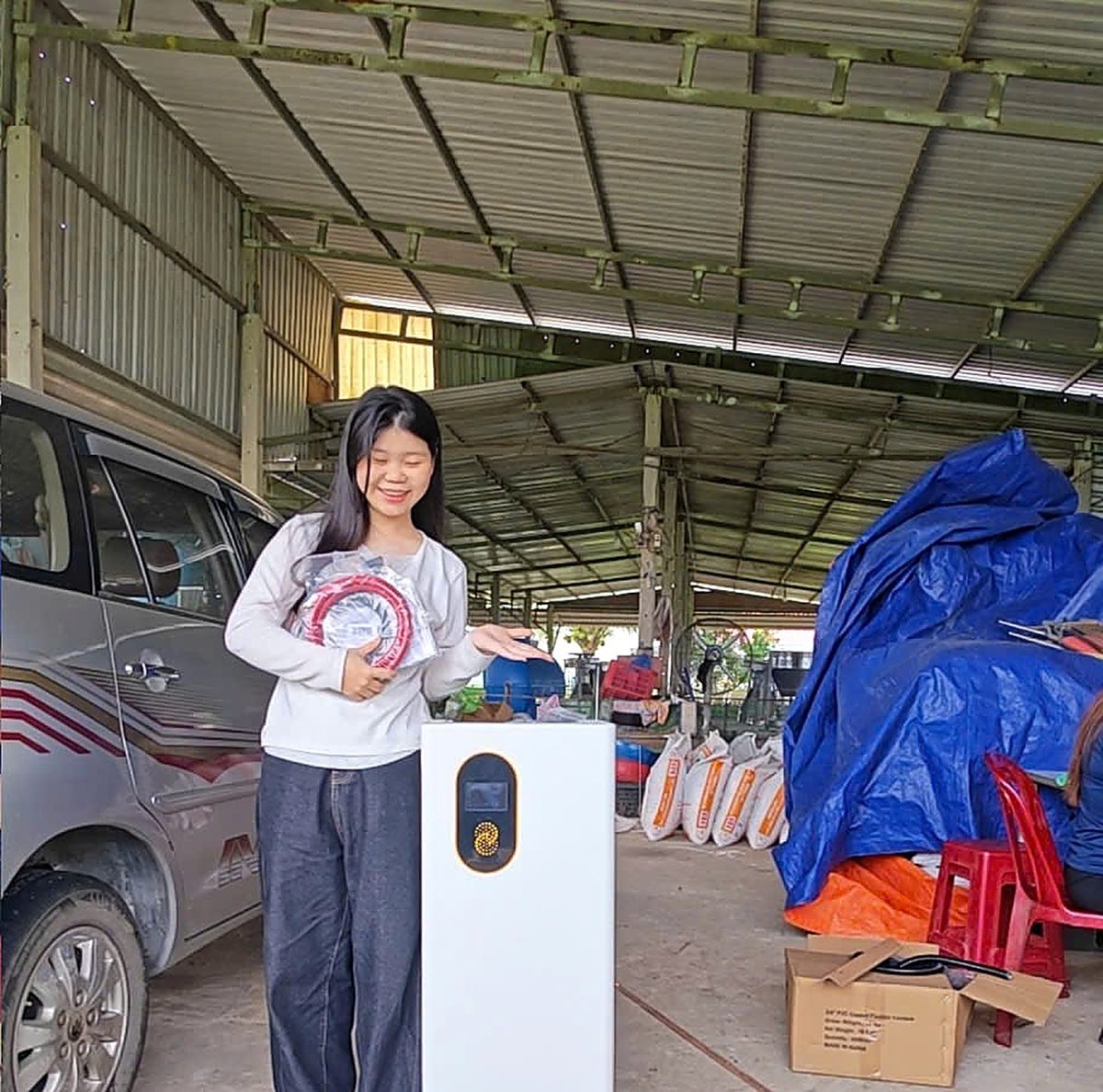 Khách hàng đứng cạnh tủ pin lưu trữ vừa được Minh Thắng Solar bàn giao tại Tây Ninh